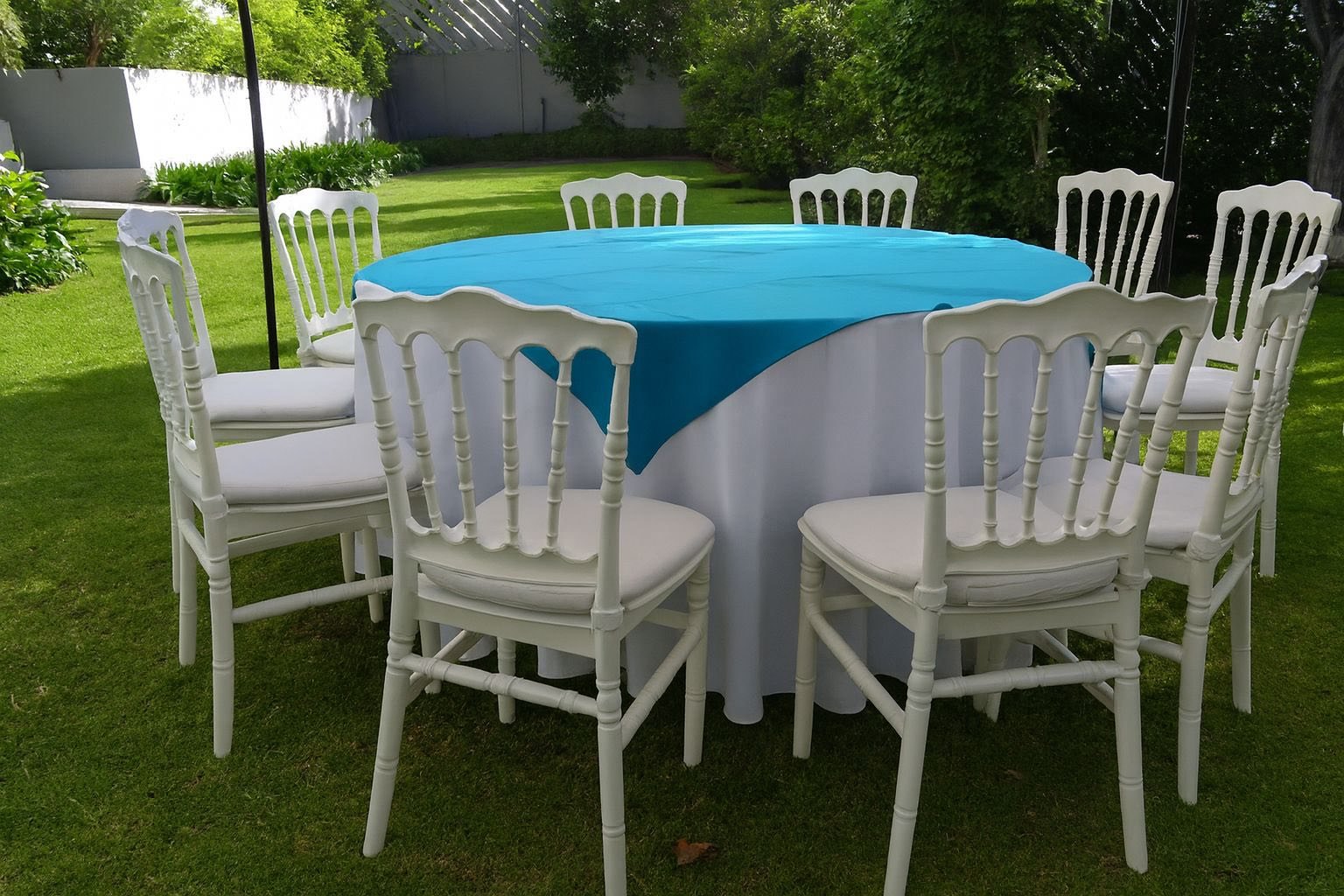 Sillas Tiffany blancas con mantel turquesa